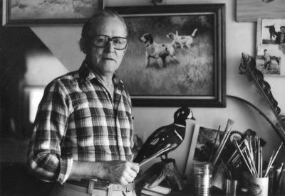 Black and white photo of wildlife artist Bob Hines in art studio.